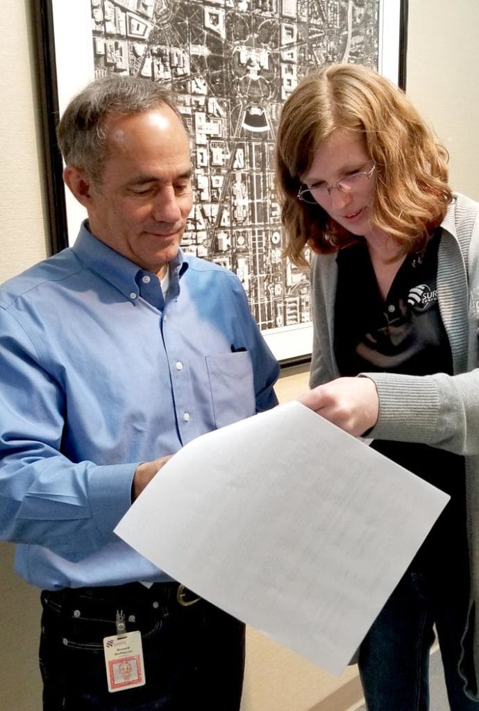 Surdex employees looking at a report
